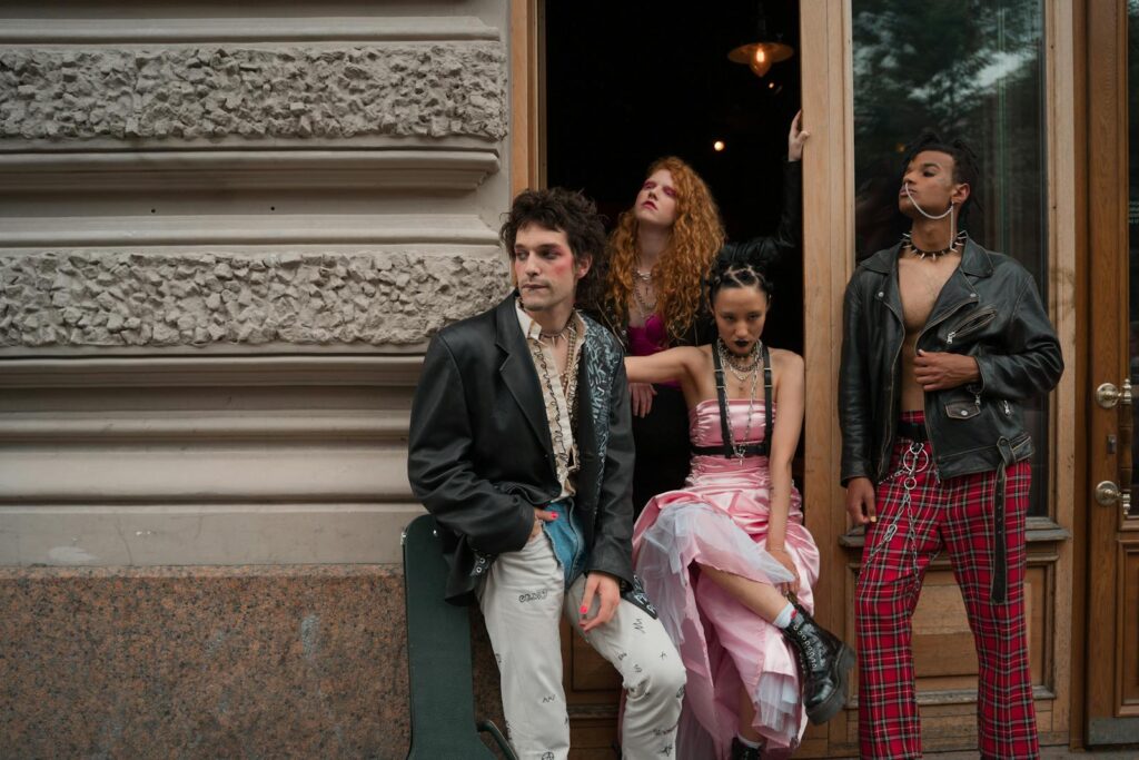 Four young adults in punk fashion pose against an urban backdrop, showcasing diversity and edgy style.