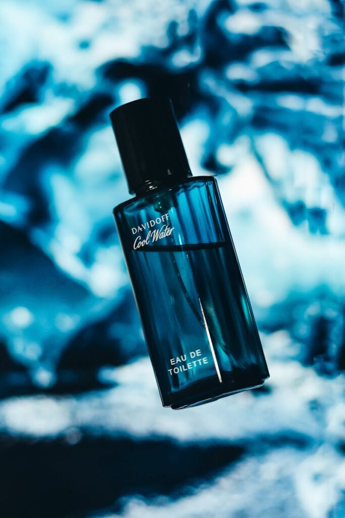 Luxurious cologne bottle against abstract blue background, conveying a fresh fragrance feel.