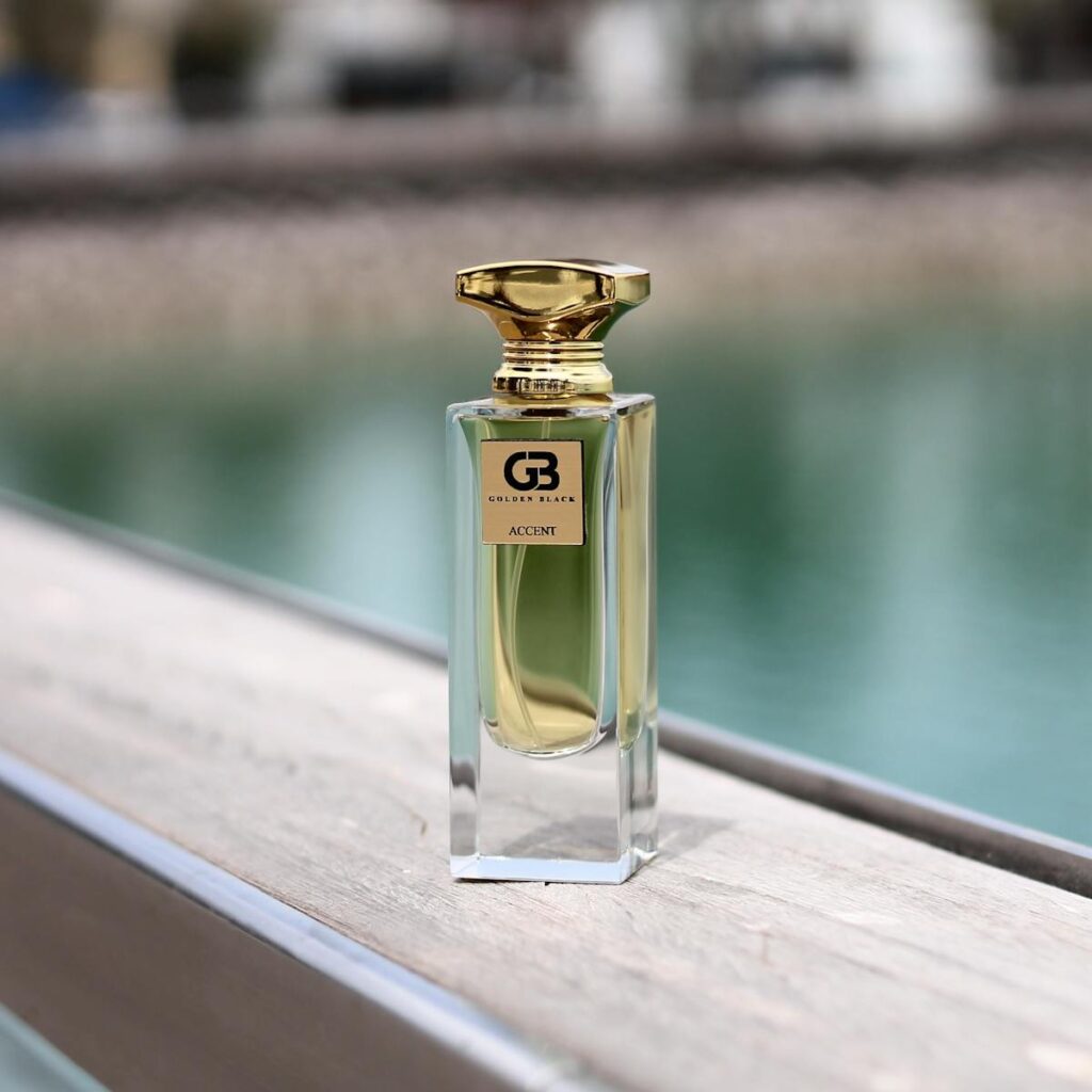 Luxurious fragrance bottle displayed outdoors by a tranquil water setting.