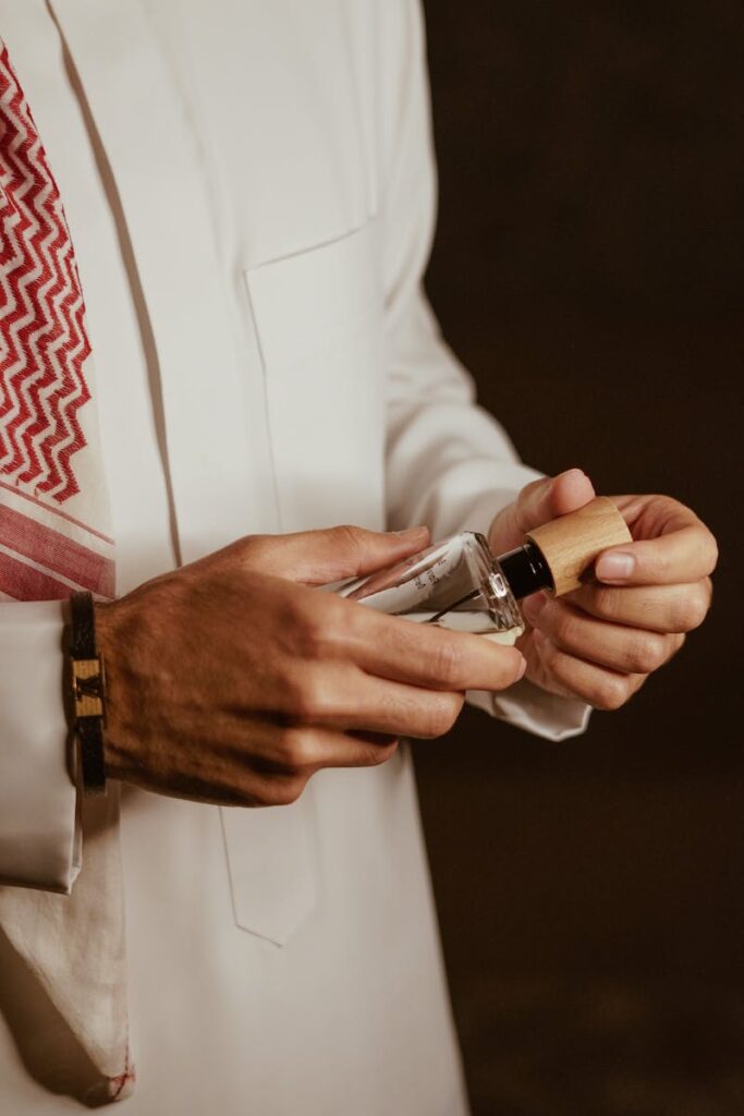Close-up of a man's hands holding a perfume bottle with elegance and style.