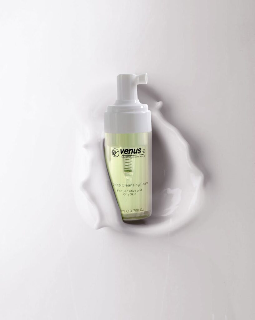Foaming cleanser bottle against a smooth liquid backdrop, highlighting skincare elegance.
