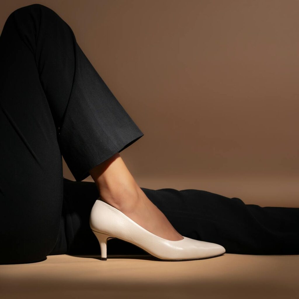 Stylish white heels paired with formal black pants, showcasing elegance and fashion.
