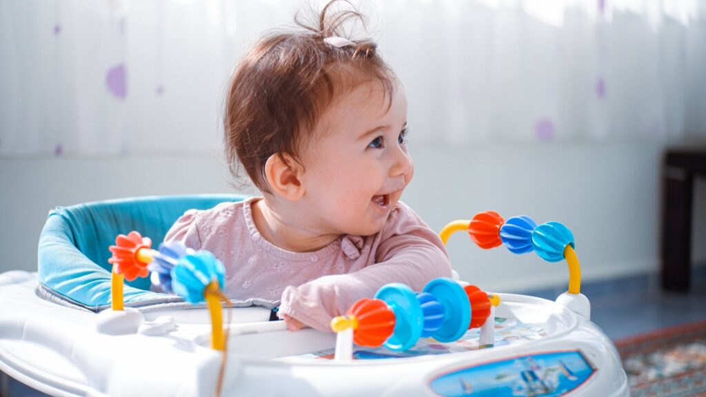 A joyful baby enjoying playtime in a vibrant walker indoors.