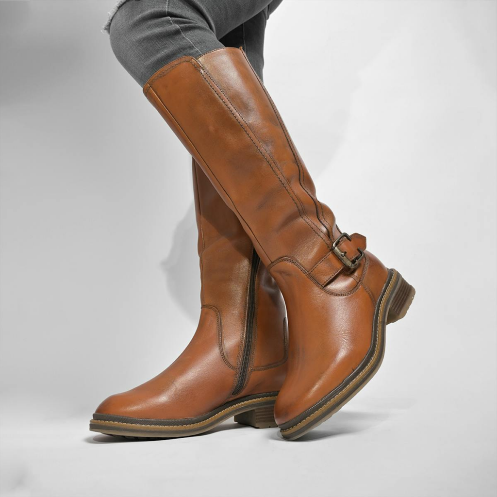 Stylish brown leather knee-high boots against a simple backdrop.
