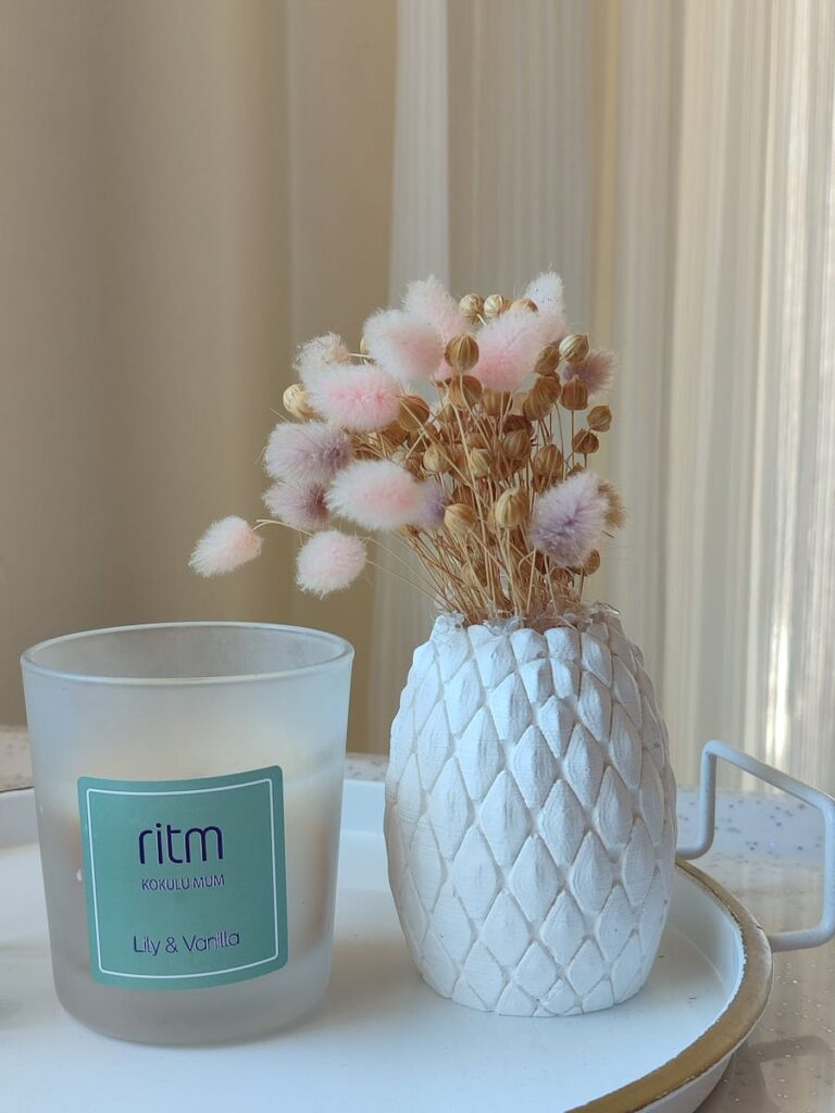 Charming interior decor featuring a pastel floral arrangement and a scented candle.