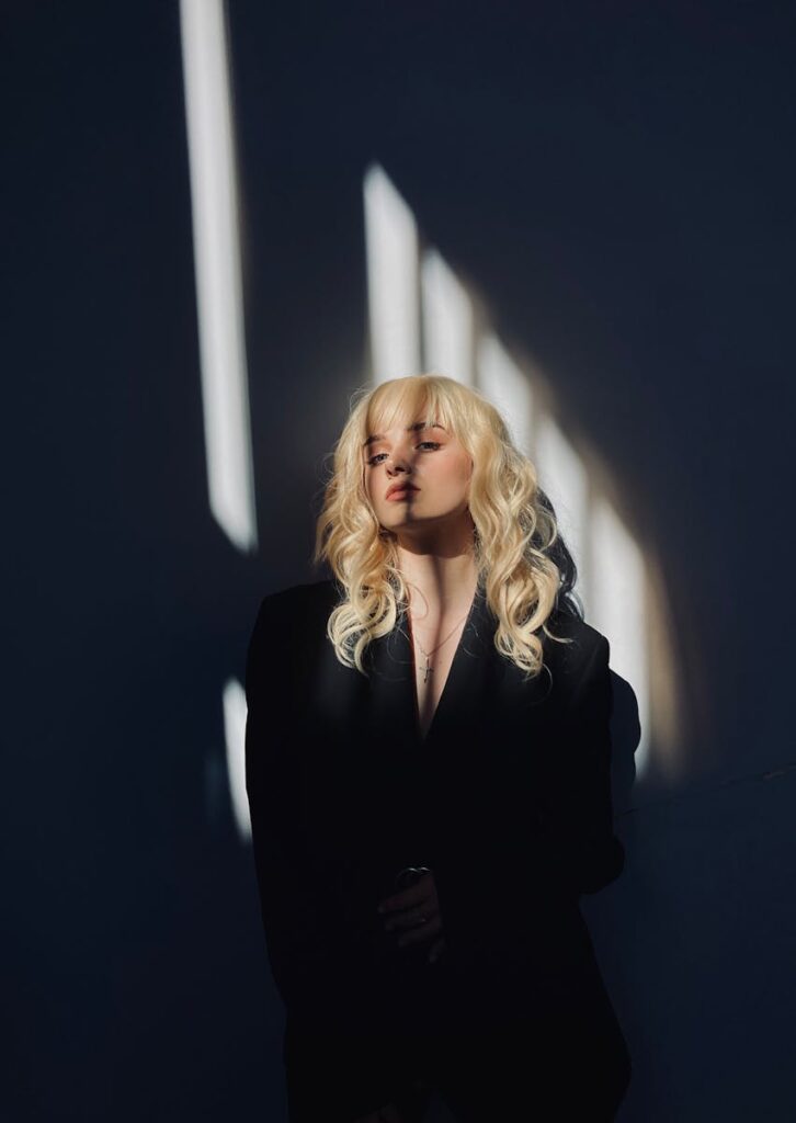Mystical portrait of a woman with blonde hair in dramatic lighting and shadows.