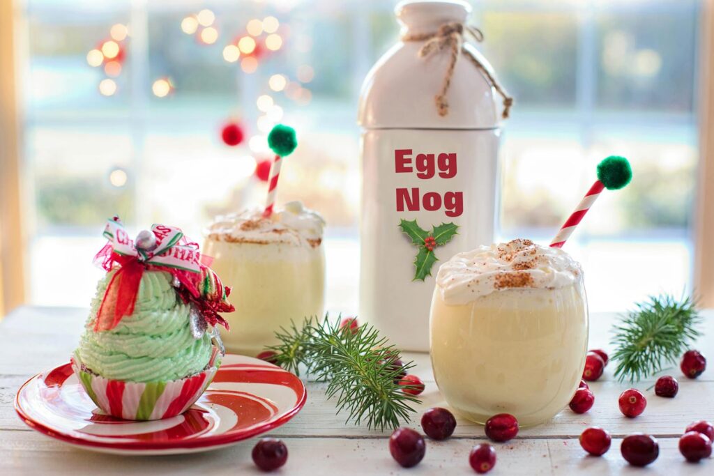 Charming Christmas display with eggnog and festive cupcake on a table, perfect for the holiday season.
