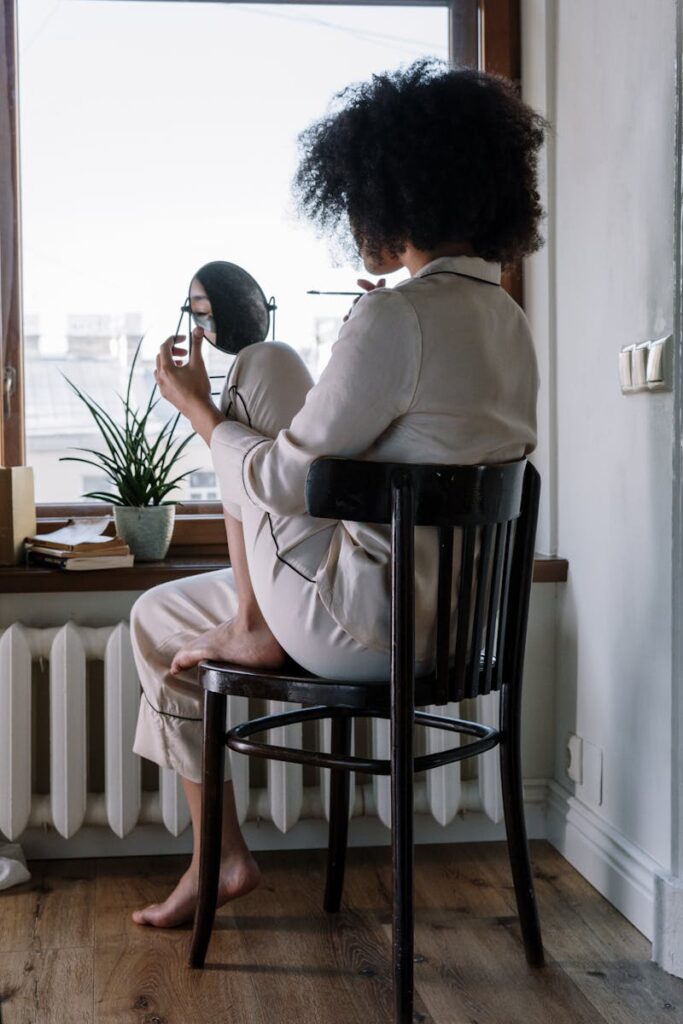 Woman enjoying a cozy morning skincare routine at home with natural light.