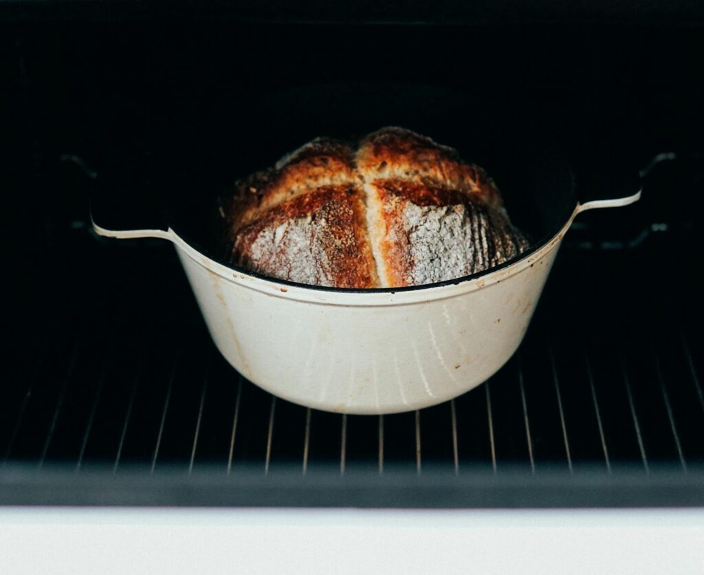 Crusty homemade bread in a Dutch oven inside an oven, perfectly baked for gourmet taste.