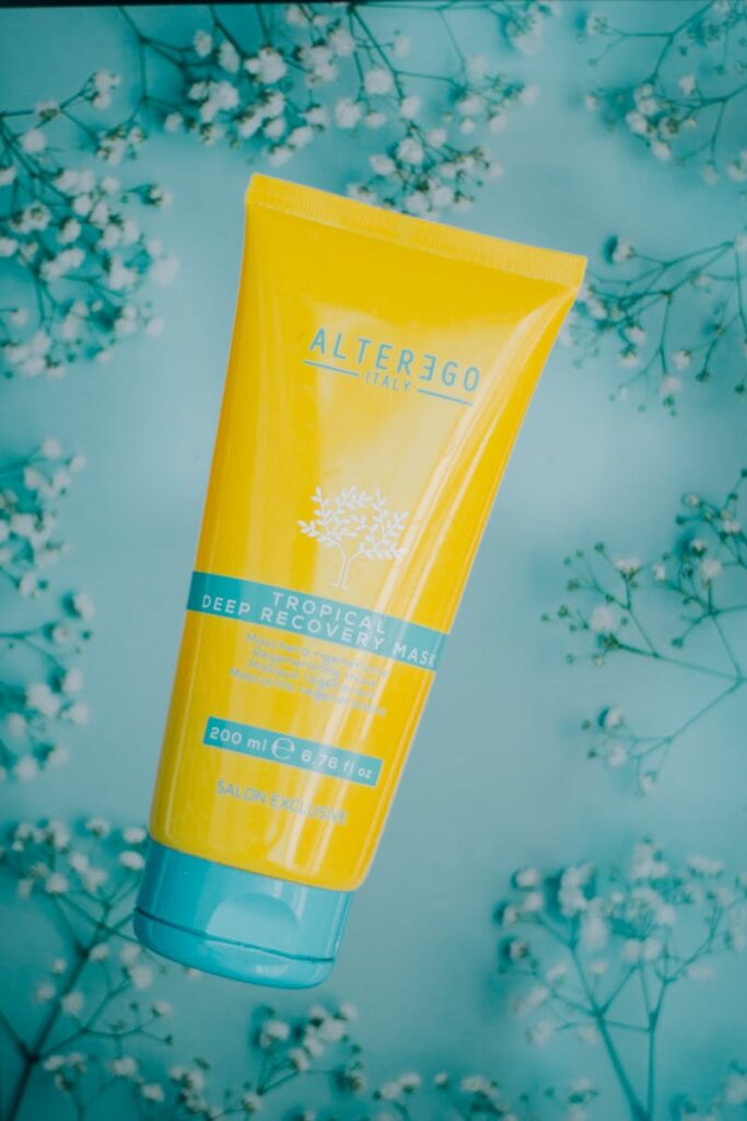 Yellow cosmetic tube with floral backdrop, ideal for skincare promotions.