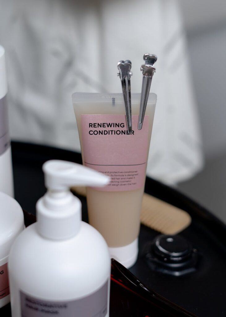 Stylish arrangement of haircare products with renewing conditioner and clips on a tray.