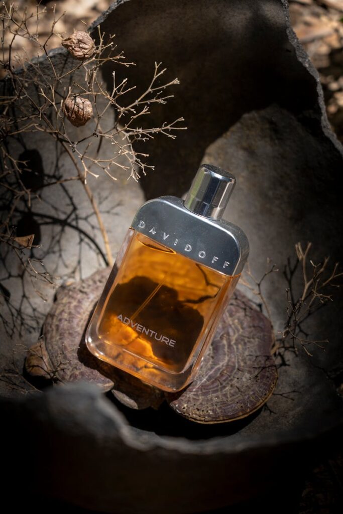 Close-up of Davidoff Adventure perfume bottle surrounded by rustic elements, highlighting elegance and adventure.