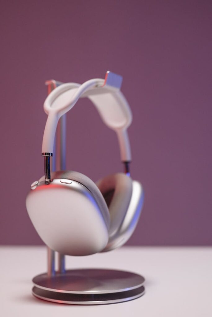 Stylish silver wireless headphones on a stand with a modern minimalist design and copy space.