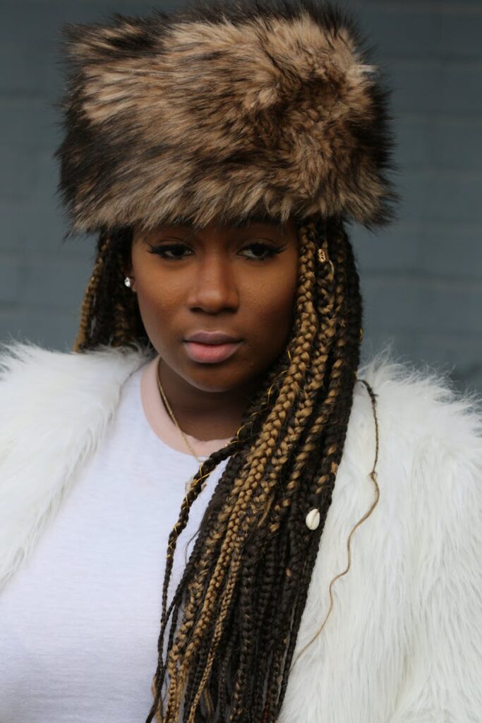 Portrait of a woman in New York wearing a faux fur hat and braided hair, expressing fashion and style.