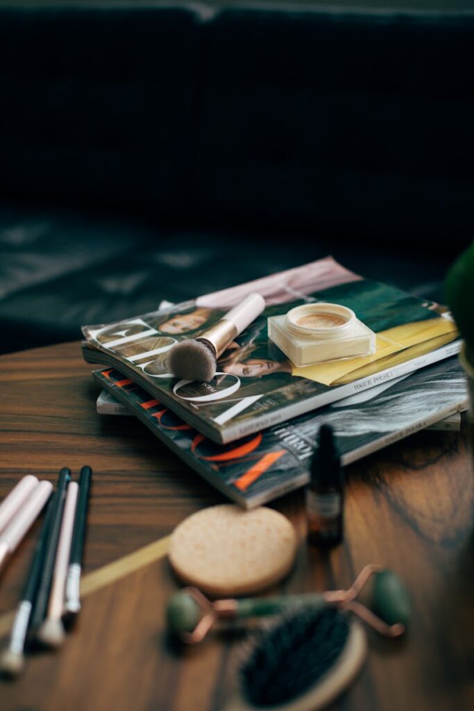 Beauty products and magazines on a wood table, perfect for self-care themes.