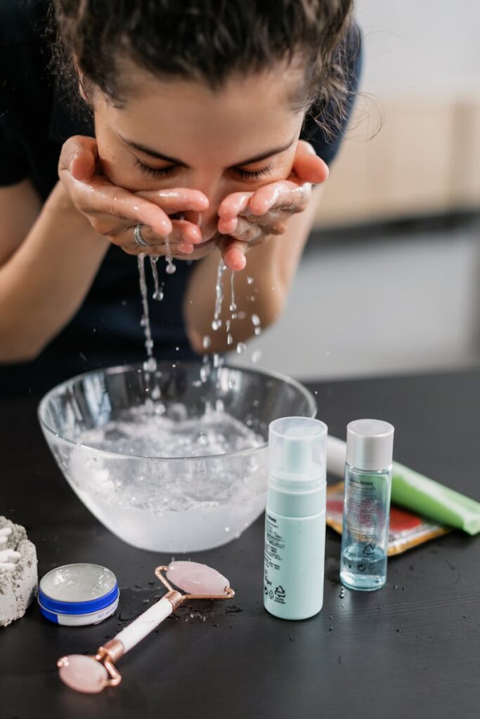 A woman practicing her skincare routine with a face wash and products on a counter.