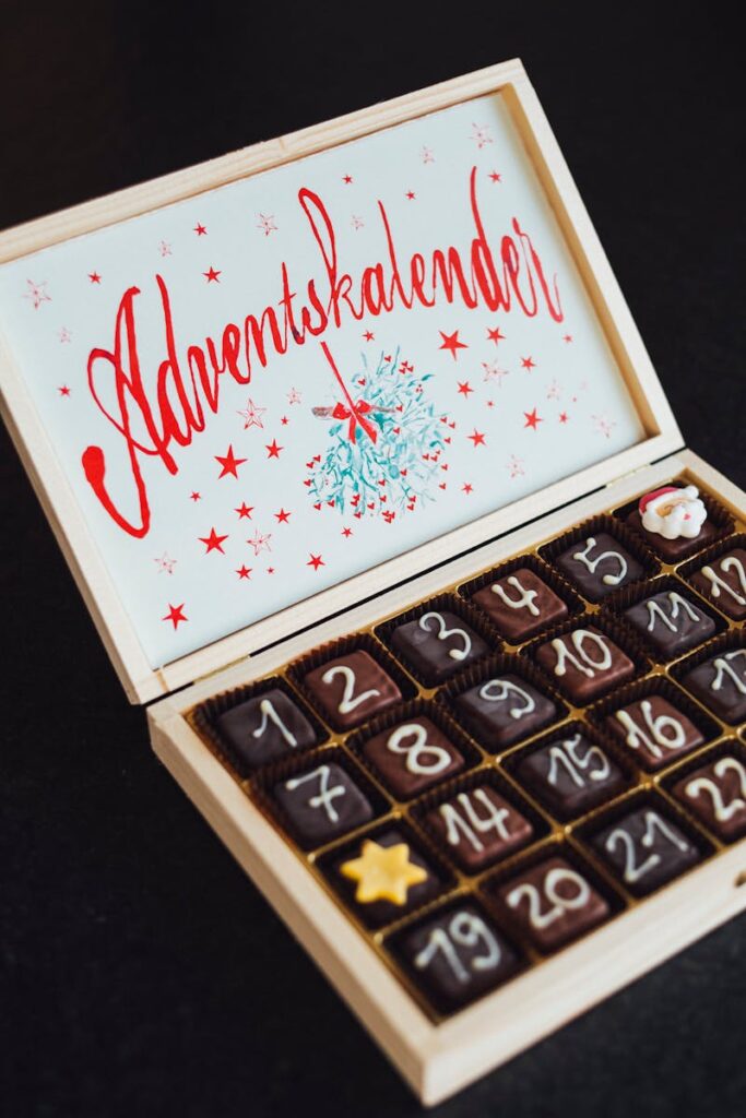 Wooden advent calendar filled with chocolates, decorated with numbers and stars.