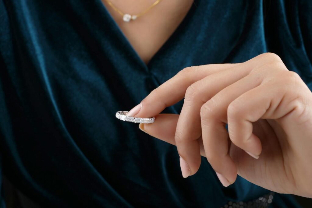 Close-up of a hand holding a diamond ring, showcasing elegant jewelry details.