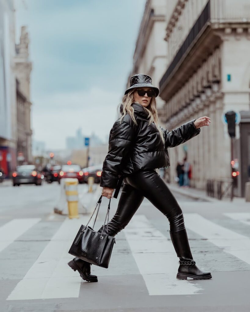 Fashionable woman in urban setting crossing a crosswalk in stylish attire.