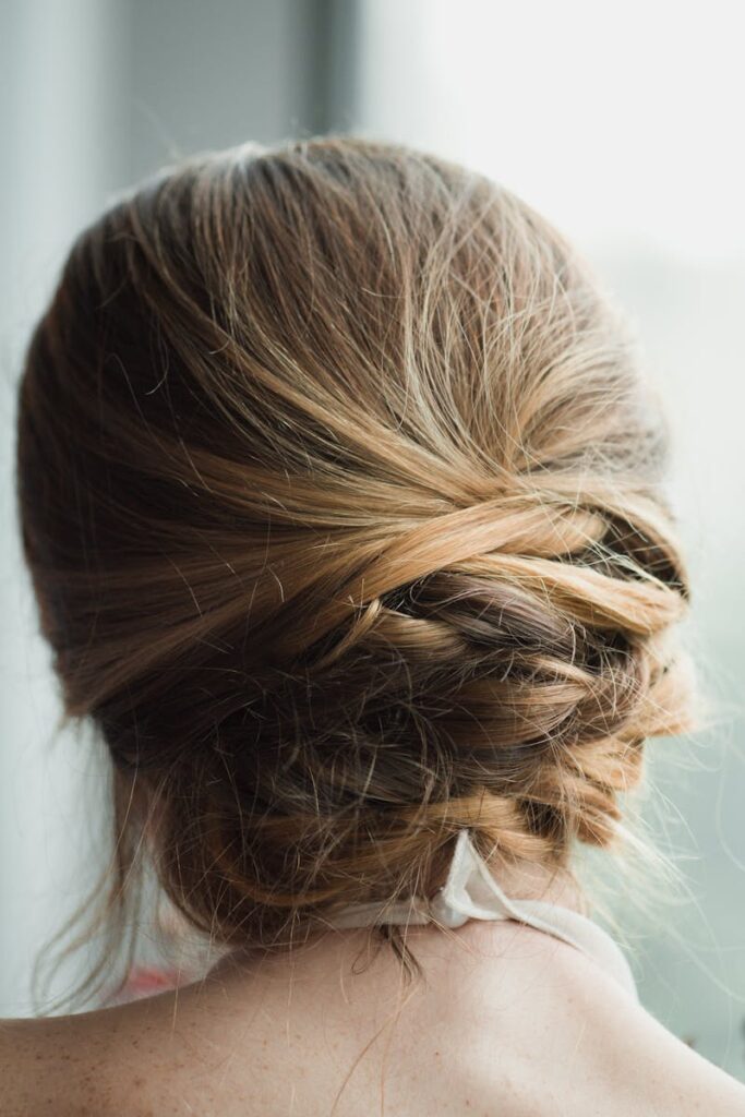 Close-up of an elegant blonde updo hairstyle viewed from behind, perfect for weddings.