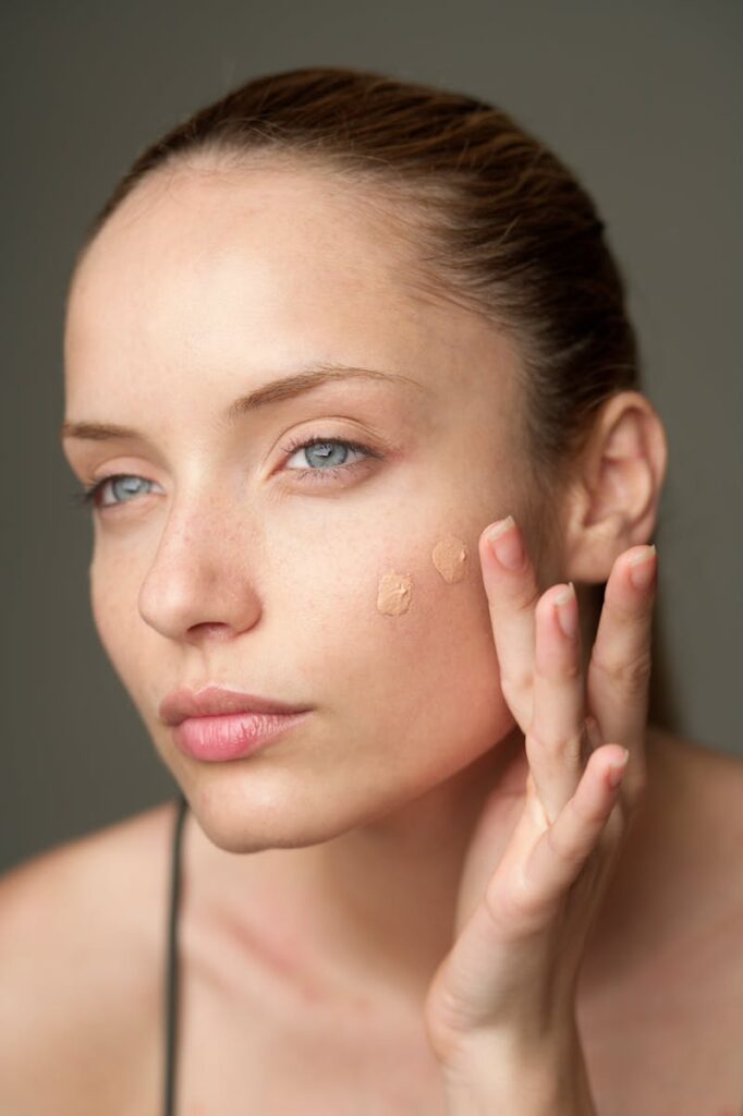 Close-up of a woman applying foundation, highlighting a natural skincare routine.