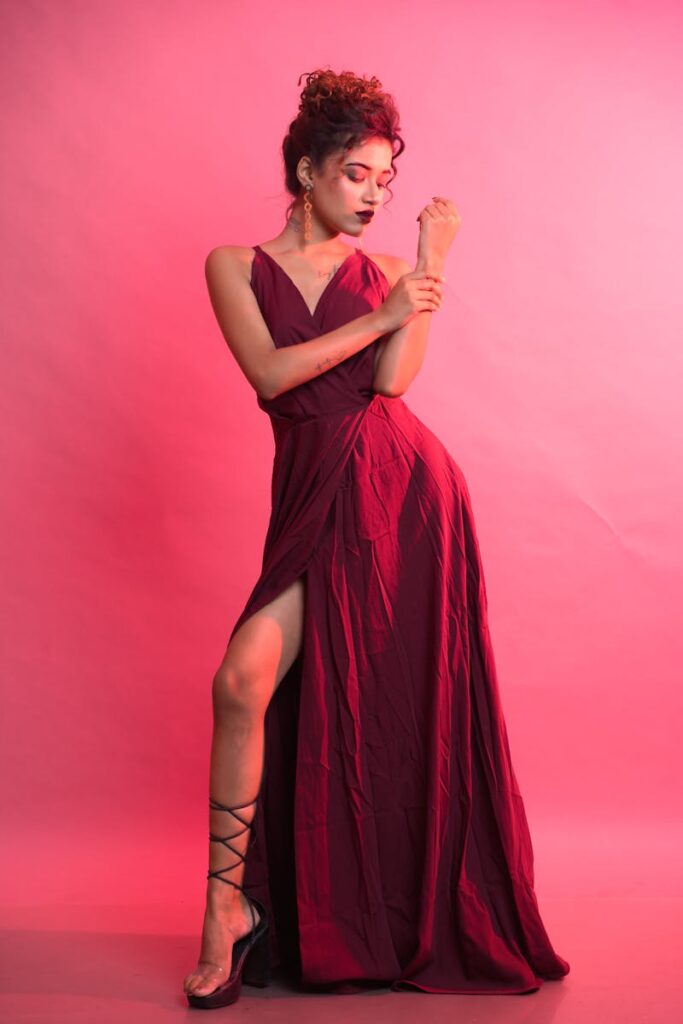 Stylish portrait of a woman in a burgundy maxi dress during a studio shoot.