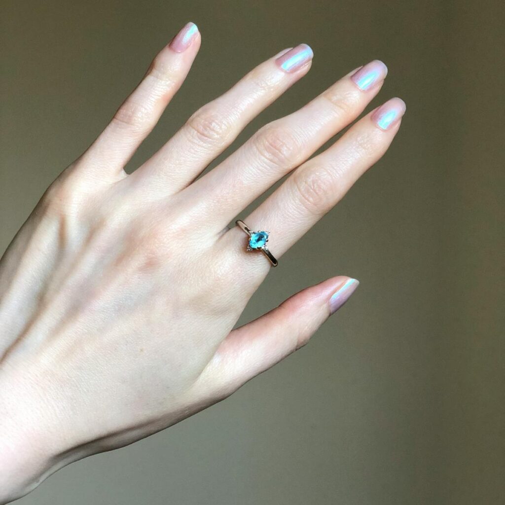 A close-up shot of a hand displaying a minimalistic gemstone ring, ideal for jewelry and fashion themes.