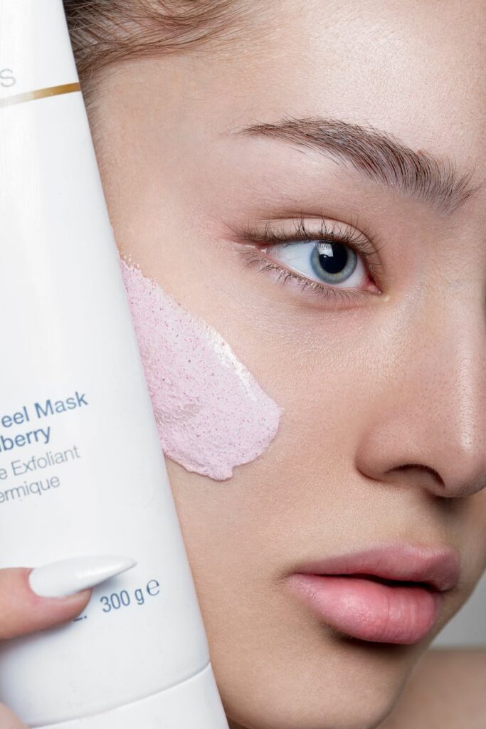 Close-up of a woman applying skincare mask with product visible, showcasing beauty routine.