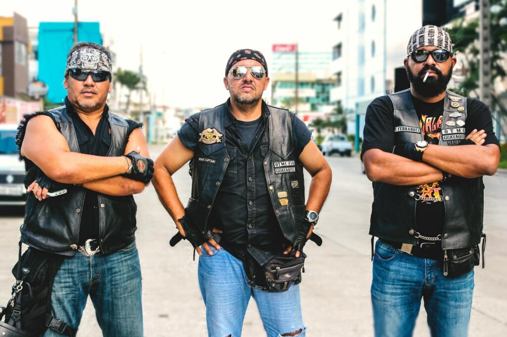 Three bikers in vests and sunglasses posing confidently on a street in Guayaquil, Ecuador.