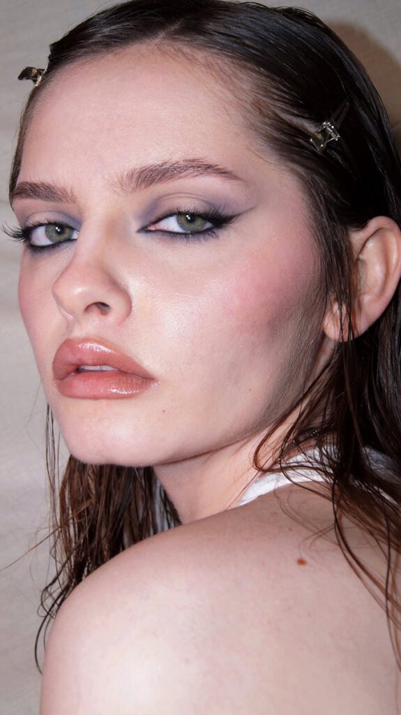 Close-up portrait showcasing bold and dramatic makeup on a woman.