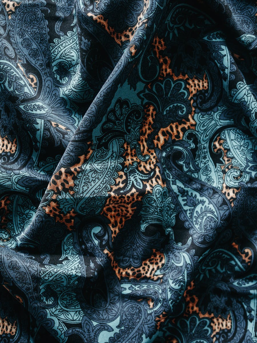 Close-up of a colorful paisley fabric with intricate patterns and bold textures.