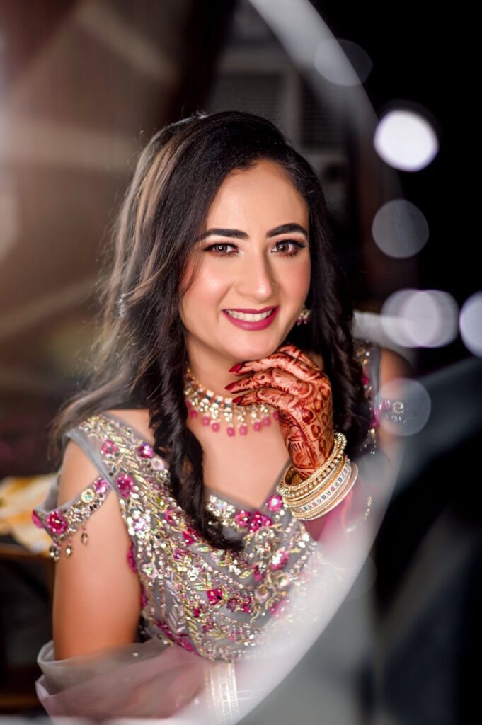 Elegant portrait of an Indian bride with intricate henna, luxury jewelry, and traditional attire, capturing her radiant smile.