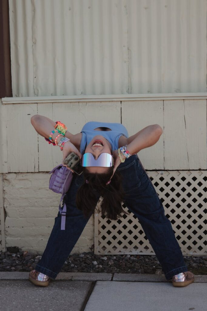 Cheerful young woman in vibrant fashion posing playfully outdoors.