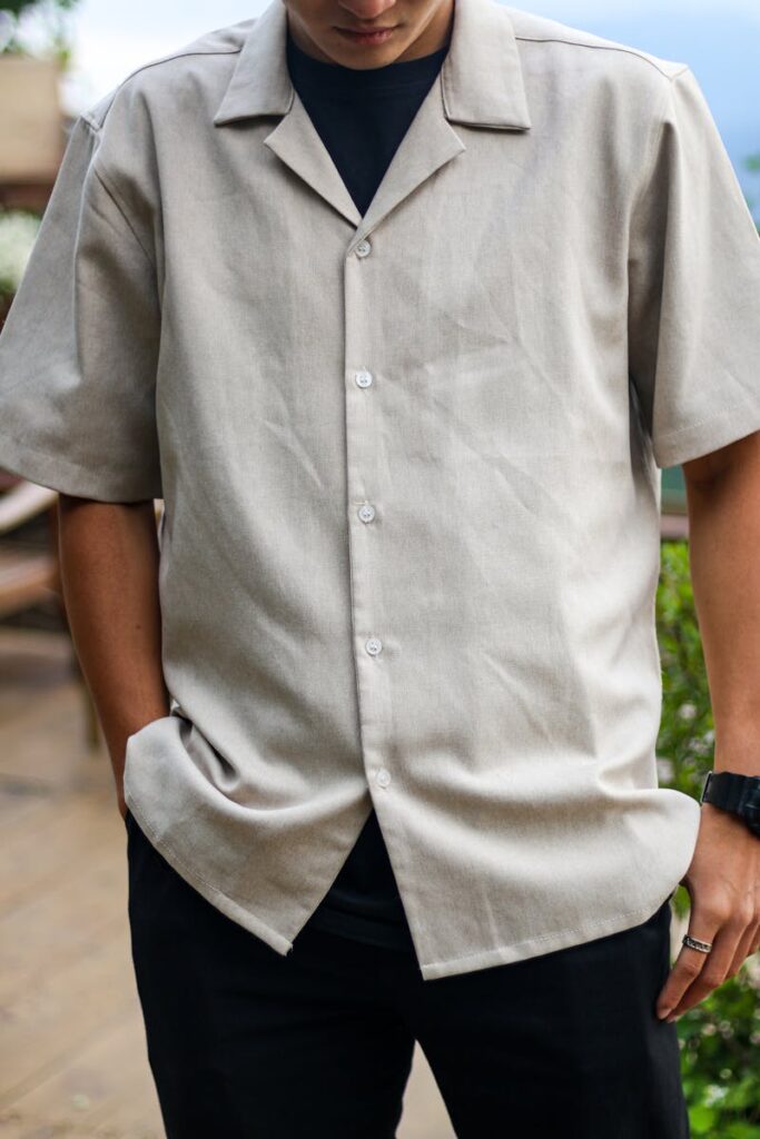 Adult male wearing a beige short-sleeve shirt outdoors, capturing a casual fashion style.