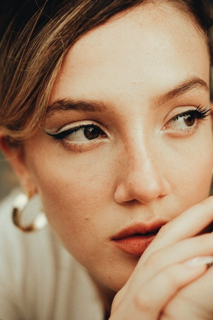 Intimate close-up of a woman's face with captivating eyes and elegant makeup.