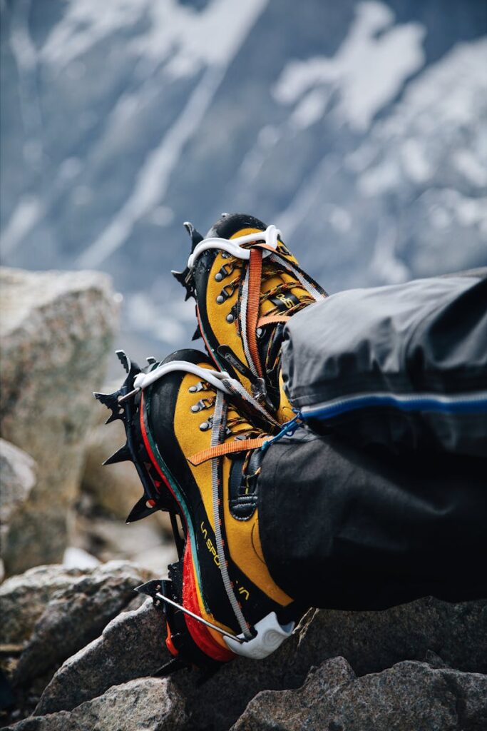 Climber's boots with crampons on rocky terrain during a winter mountain expedition.