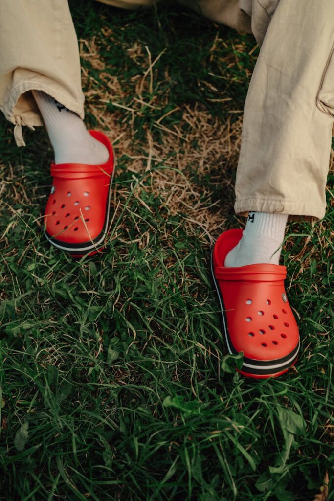 Casual red clogs on grass, showcasing a trendy and relaxed outdoor vibe.
