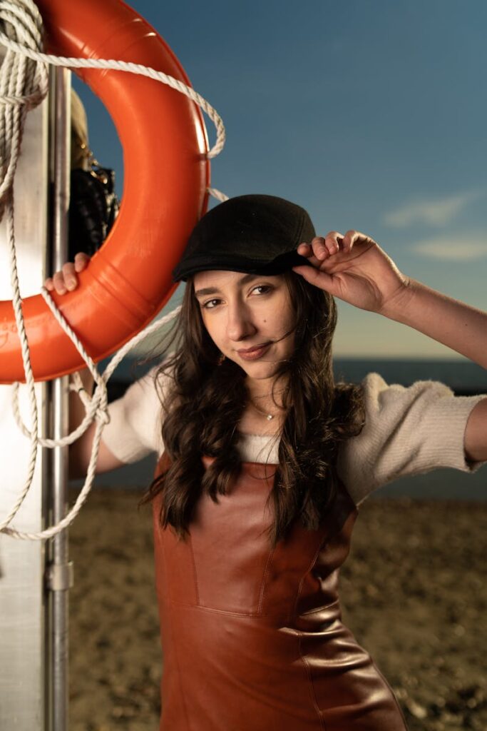 Stylish portrait of a young woman posing by a lifebuoy at the beach in Toronto.