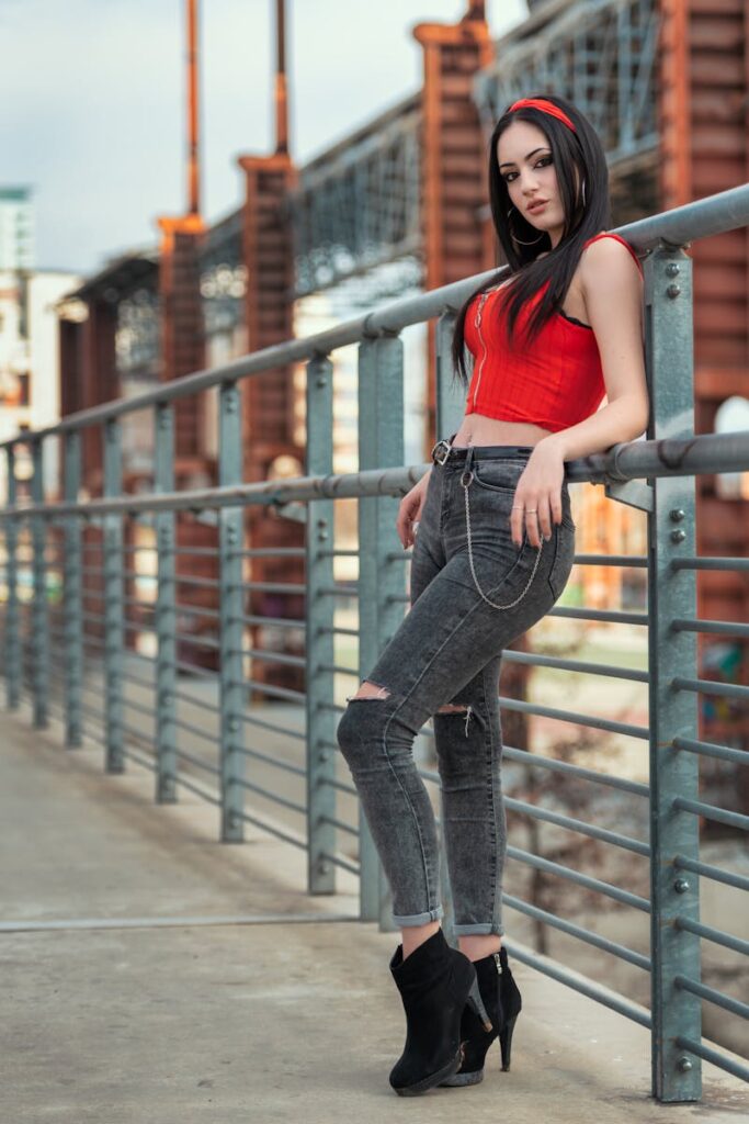 Chic young woman posing confidently in urban setting wearing trendy attire.