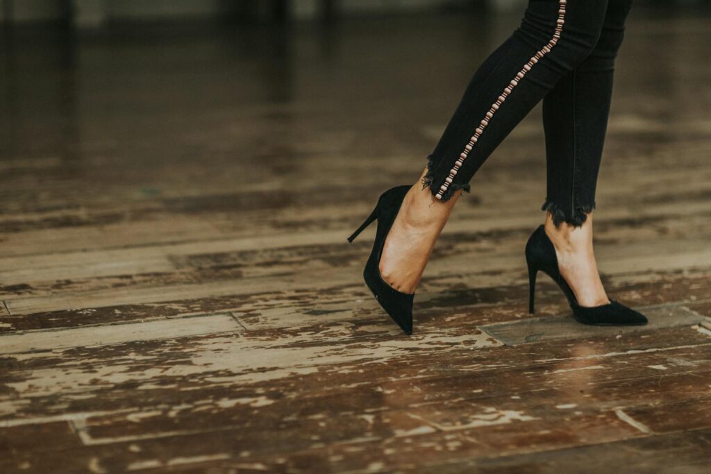 Stylish high heels on a rustic wooden floor, showcasing fashion and elegance.