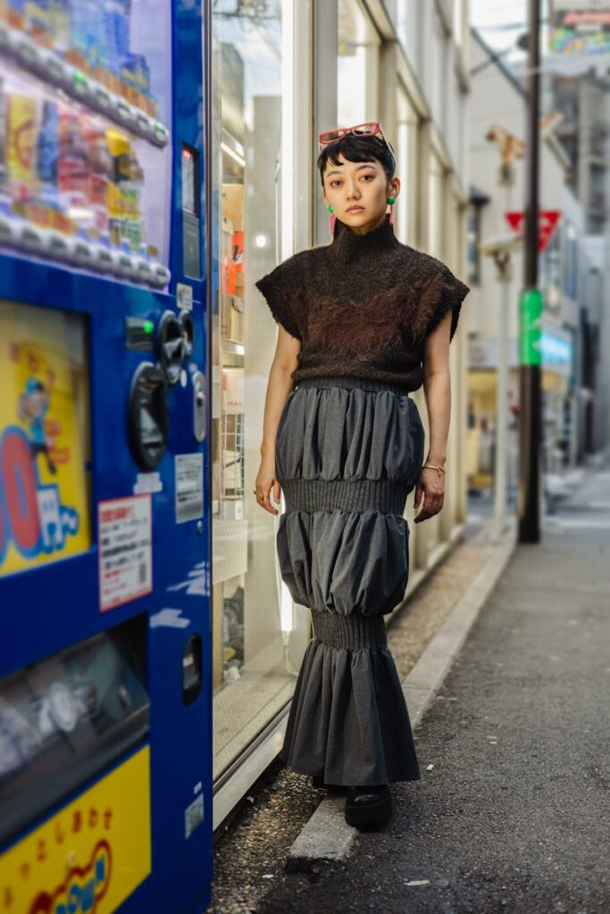 Stylish woman in Tokyo's urban landscape, wearing a chic skirt and sweater.