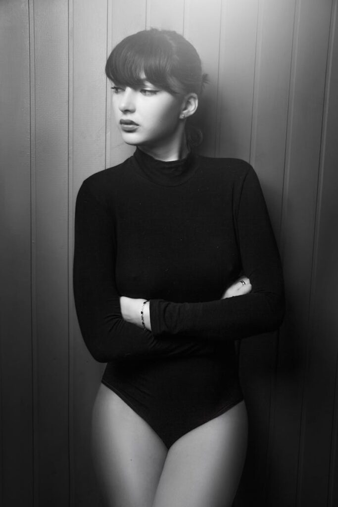 Artistic black and white portrait of a woman in a stylish pose.