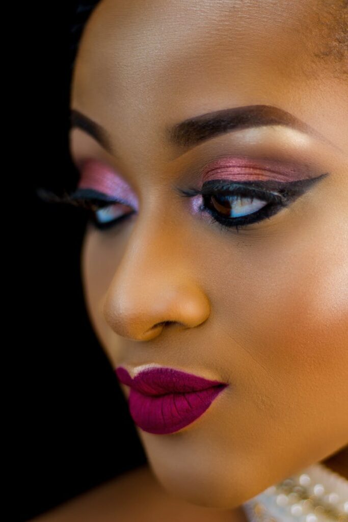 Elegant close-up portrait of a woman with dramatic makeup and lush lipstick.