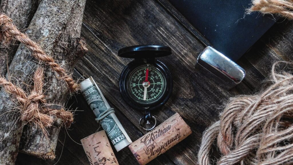 A compass and other travel essentials laid out for a vintage adventure feel.