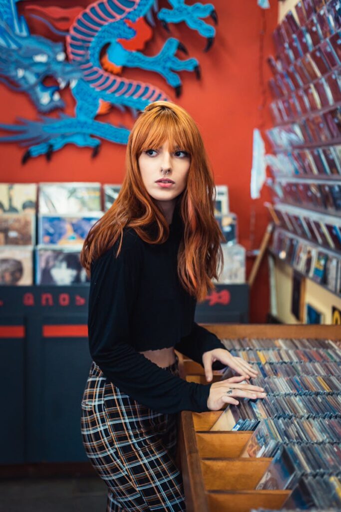 A woman with red hair explores a vibrant music store showcasing various albums.