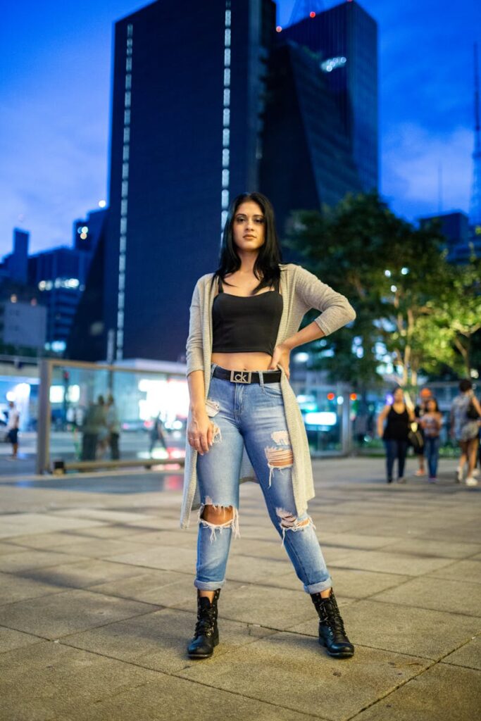 Stylish woman standing confidently in São Paulo cityscape, showcasing urban fashion.