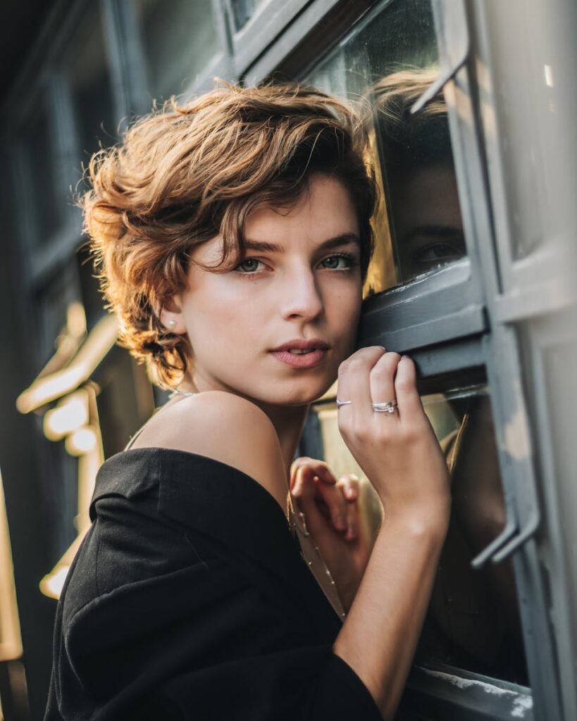 Chic portrait of a young woman with short hair and stylish attire, posing elegantly.