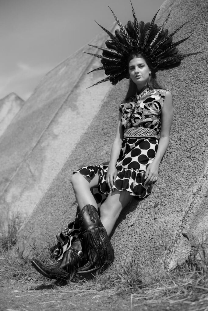 Striking black and white portrait of a woman in a bold outfit outdoors.