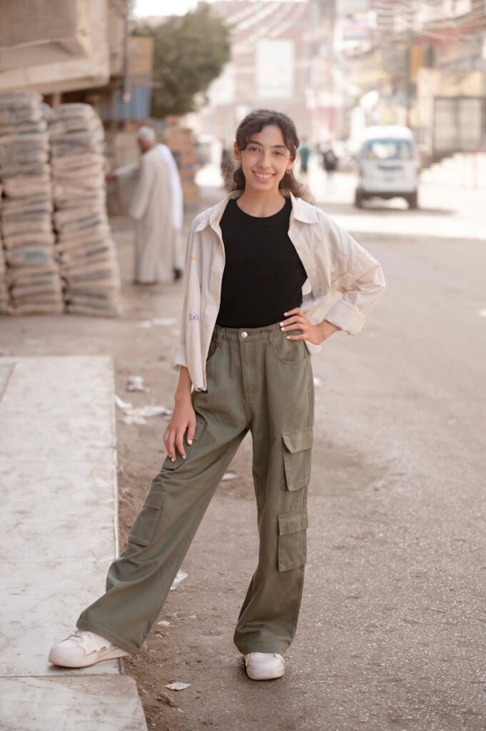 Fashionable young woman smiling in a city street, posing in style.