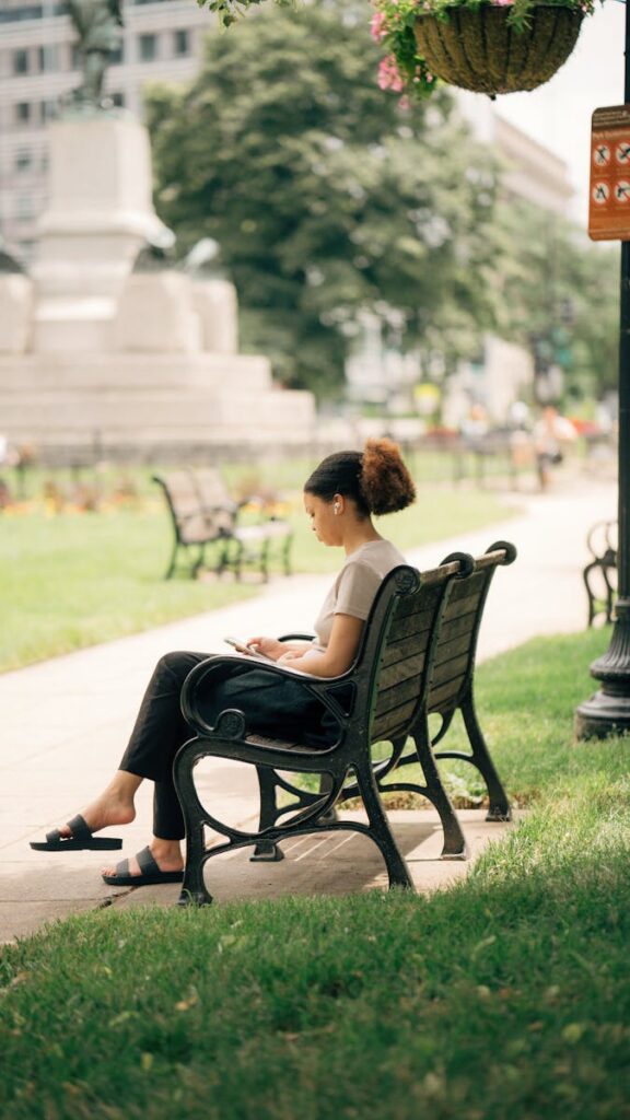 A woman sits on a park bench in Washington, DC, enjoying a peaceful moment outdoors.